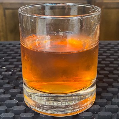 Sazerac cocktail in a rocks glass with ice cubes removed