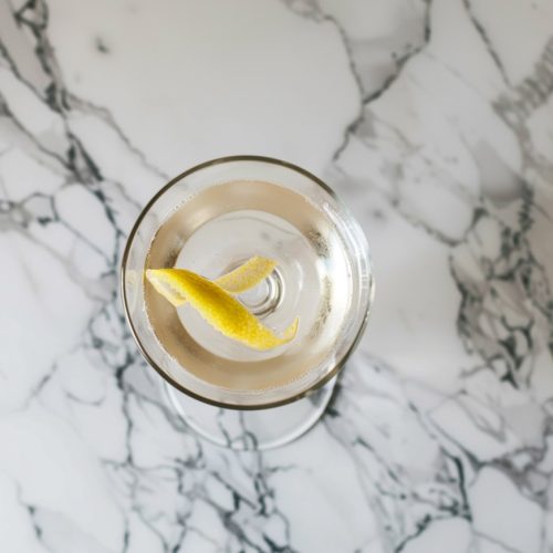 Top-down image of a gin cocktail in a chilled cocktail glass with lemon twist