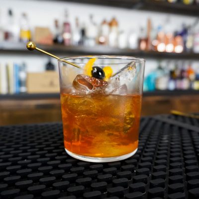 cozy cocktail with bitters and simple syrup with maraschino cherry
