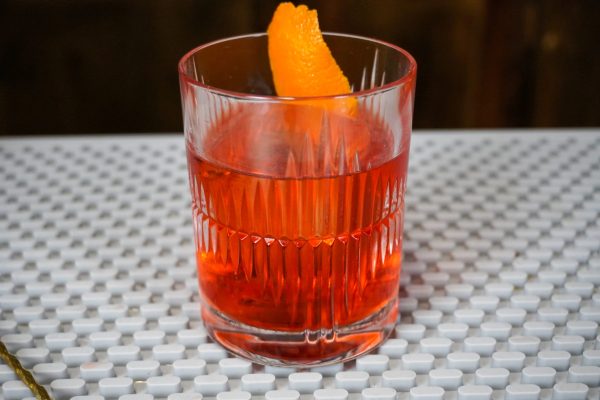 Negroni cocktail with 1 ounce sweet vermouth and 1 ounce gin in a lead-free crystal rocks glass with a larger capacity, with ice