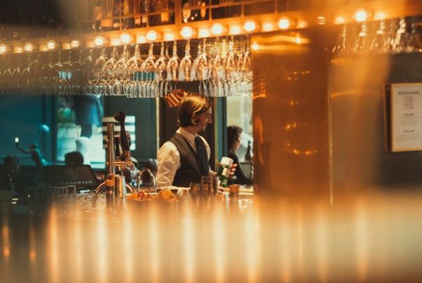 A bartender working in a well lit bar