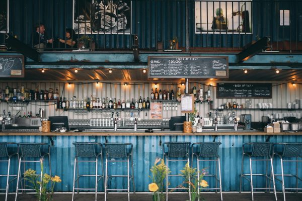 blue restaurant bar, fully stocked, with hanging lights and blue bar stools