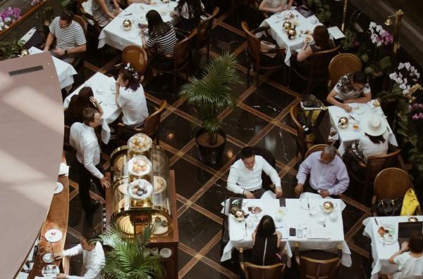 Top-down view of a busy restaurant with people sitting at tables and moving around