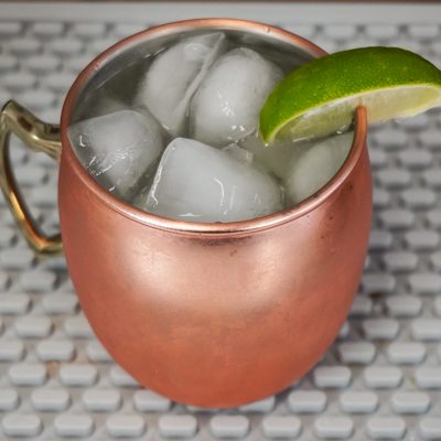 Moscow Mule is a delicious cocktail with spicy ginger beer and lime slice in a copper mug