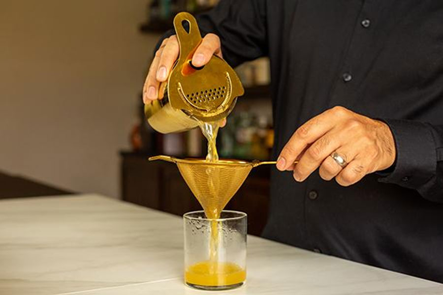 Double-straining with our gold fine strainer, copyright A Bar Above