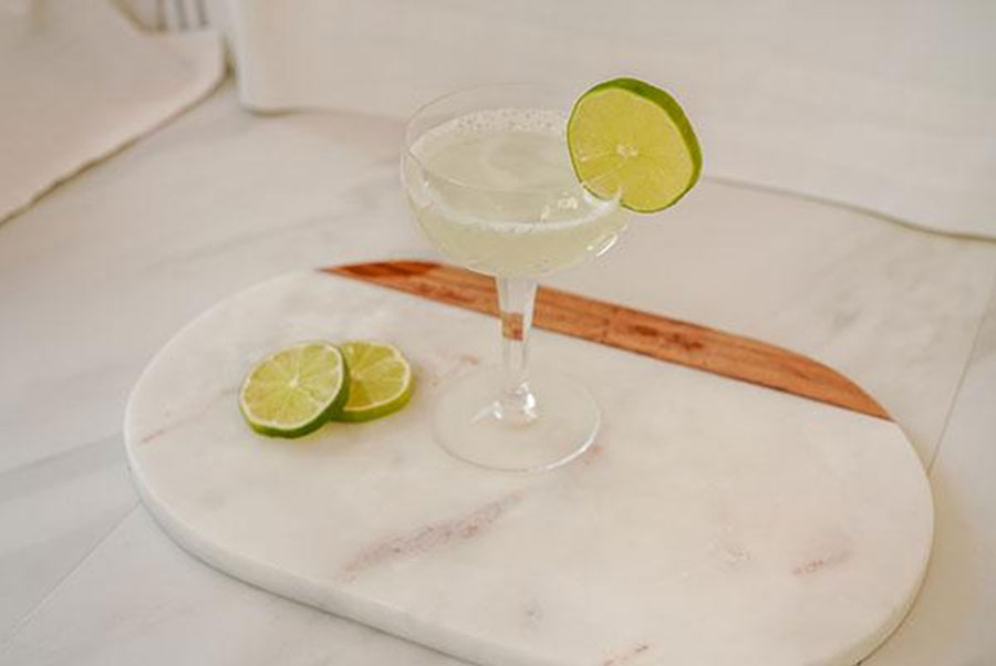 Gimlet cocktail with lime wedges
