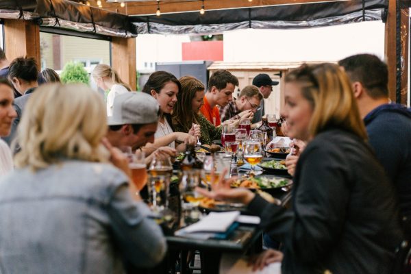 food gifts: beer lovers at a beer pairing, sitting at a table full of food and beers, by priscilla-du-preez