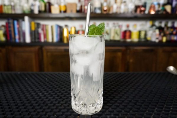 Mojito in a highball glass with 8 oz capacity made with white rum, simple syrup from granulated sugar, fresh lime juice, and extra mint for garnish