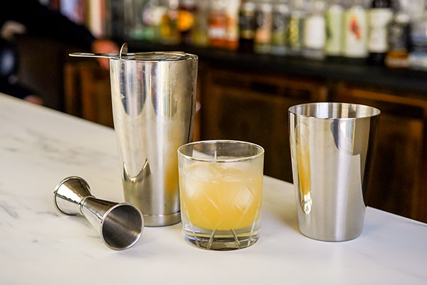 1. популярный коктейль по классическому рецепту «Маргарита» с 1 унцией апельсинового ликера и простого сиропа и 1 унцией сока лайма на барной стойке с шейкером
