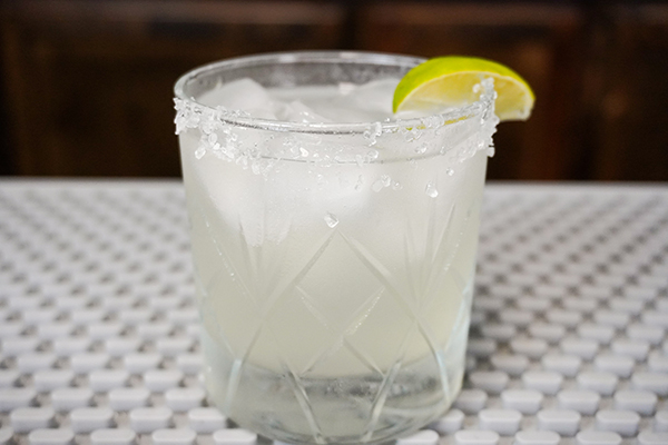 Classic Margarita Recipe in rocks glass with 1 ounce fresh lime, 1 ounce orange liqueur, ice cubes, and wedge of lime