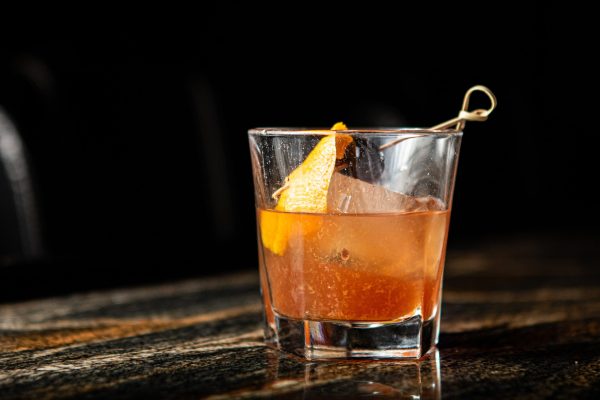 Photo of old fashioned cocktail in rocks glass with orange twist by paige ledford via unsplash