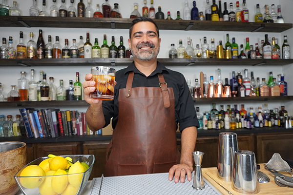 head bartender holding a cocktail behind the bar