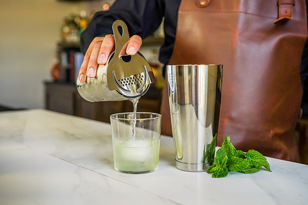 Pouring a cocktail out of a Boston shaker