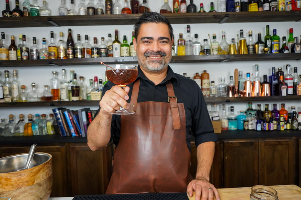 Bartender holding one of the most classic whiskey cocktails, the Manhattan