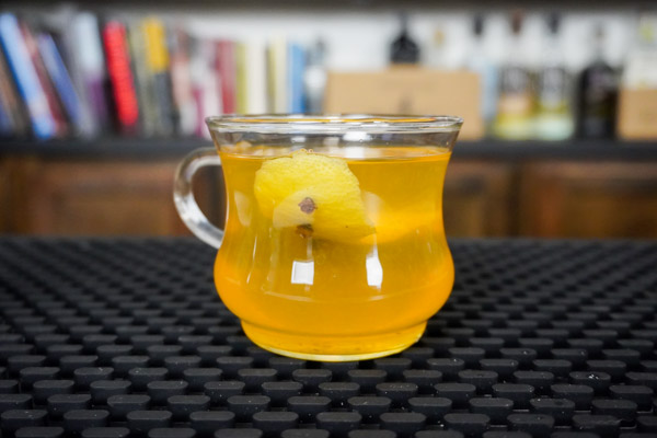 hot toddy with lemon wedge in a clear mug, great for a winter cold