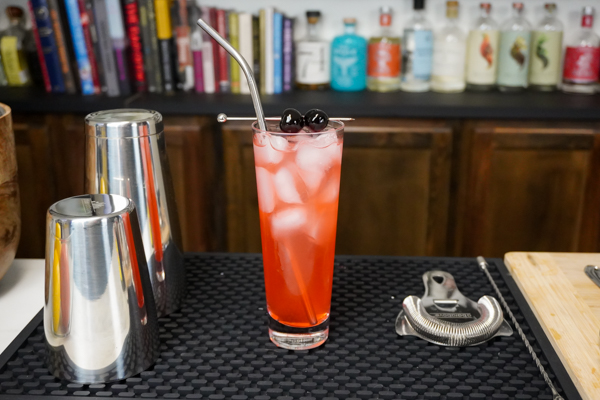 A Shirley Temple fruity drink with 2 cherries for garnish and plain vodka