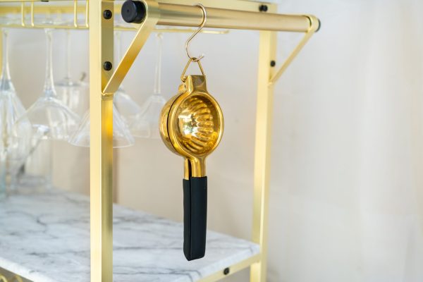 Hand juicer for citrus fruits hanging from a bar cart