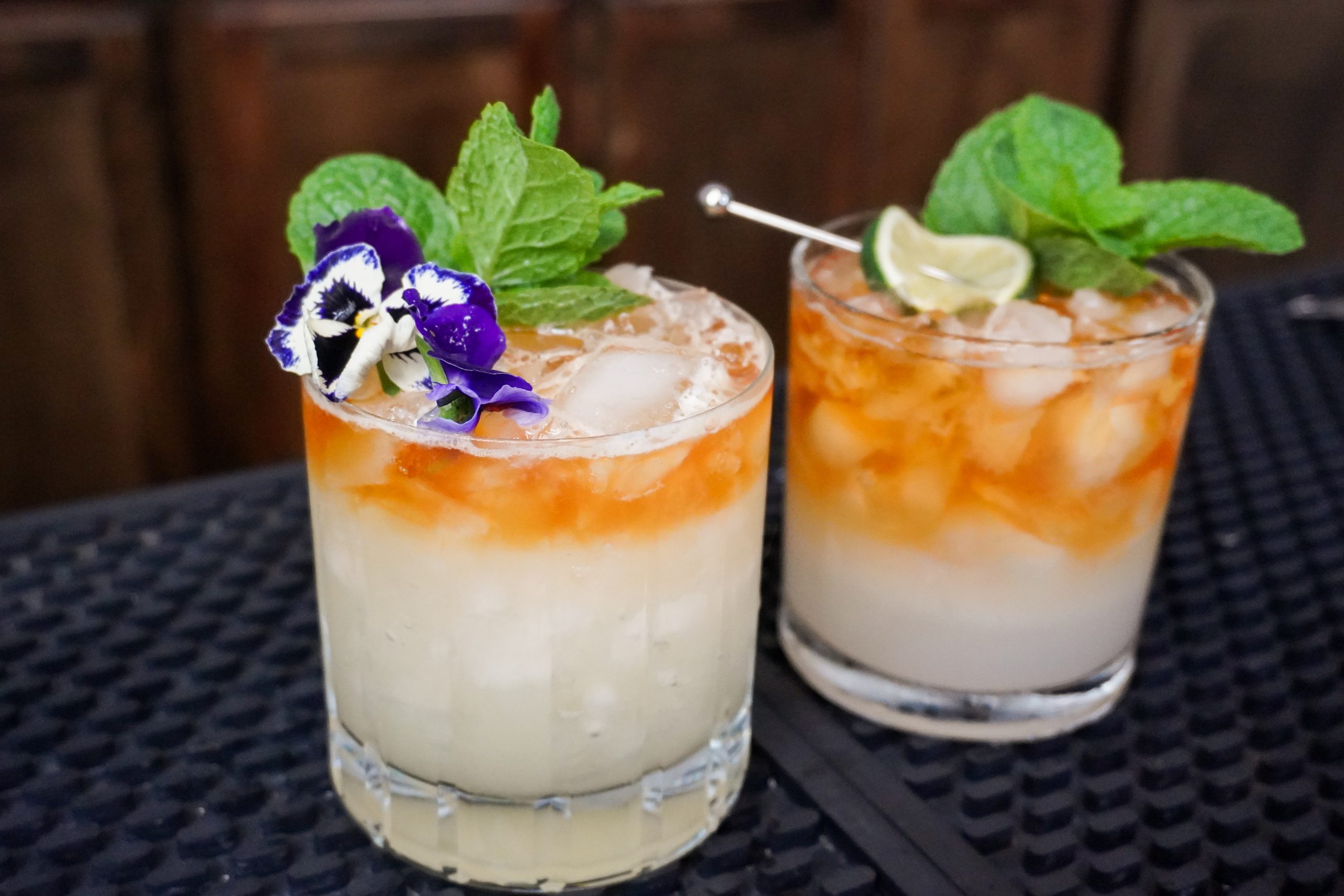 4. Trader Vic's Mai Tai named after Victor Bergeron, next to a modern Mai Tai, each with 1 ounce lime juice and sprig of mint and a dark rum float