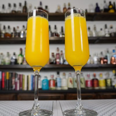 mimosa simple drink in 2 champagne flutes with two-parts champagne