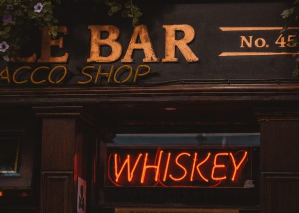2. Bar sign advertising a whiskey dinner drink by andrea-ferrario-unsplash