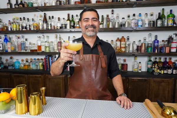 Bartender holding a cocktail in a coupe glass