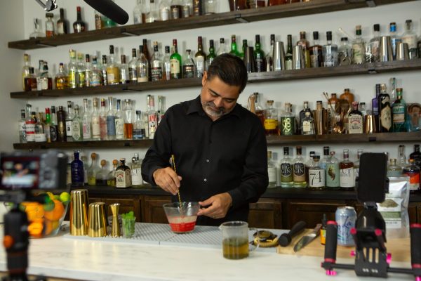 bartender stirring a non-alcoholic Mojito in a measuring cup, made with mint tea