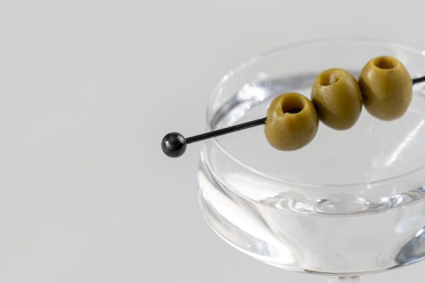 black cocktail pick in a Martini with 3 cocktail olives